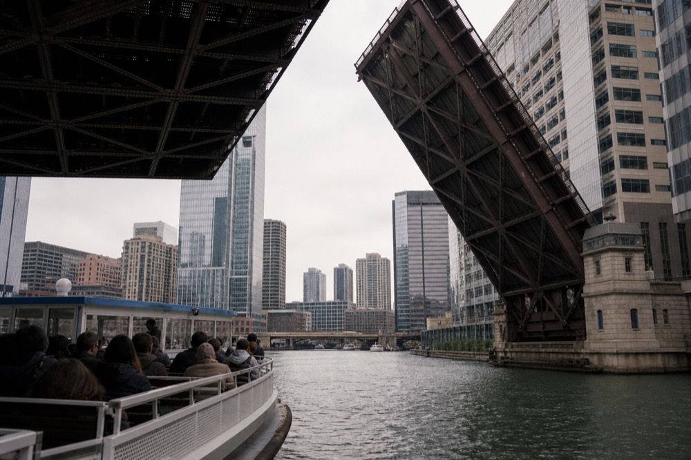 A family-friendly tour boat passing under a Chicago bascule bridge, no text, no logos, no people